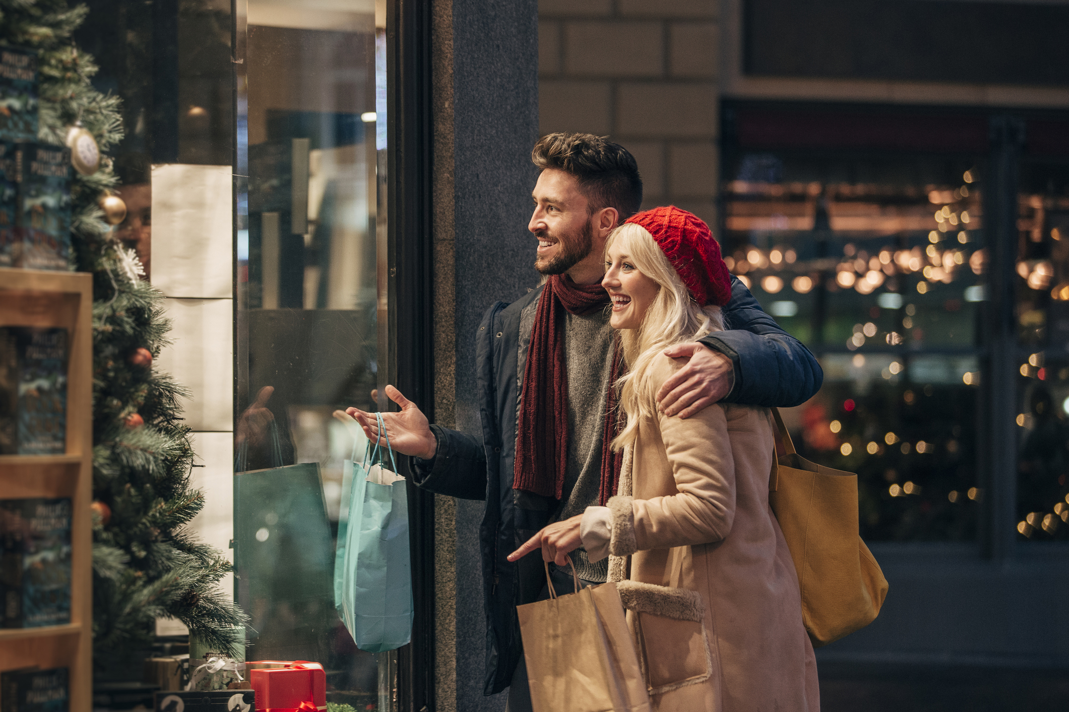 Couple looking in a store window while holiday shopping.